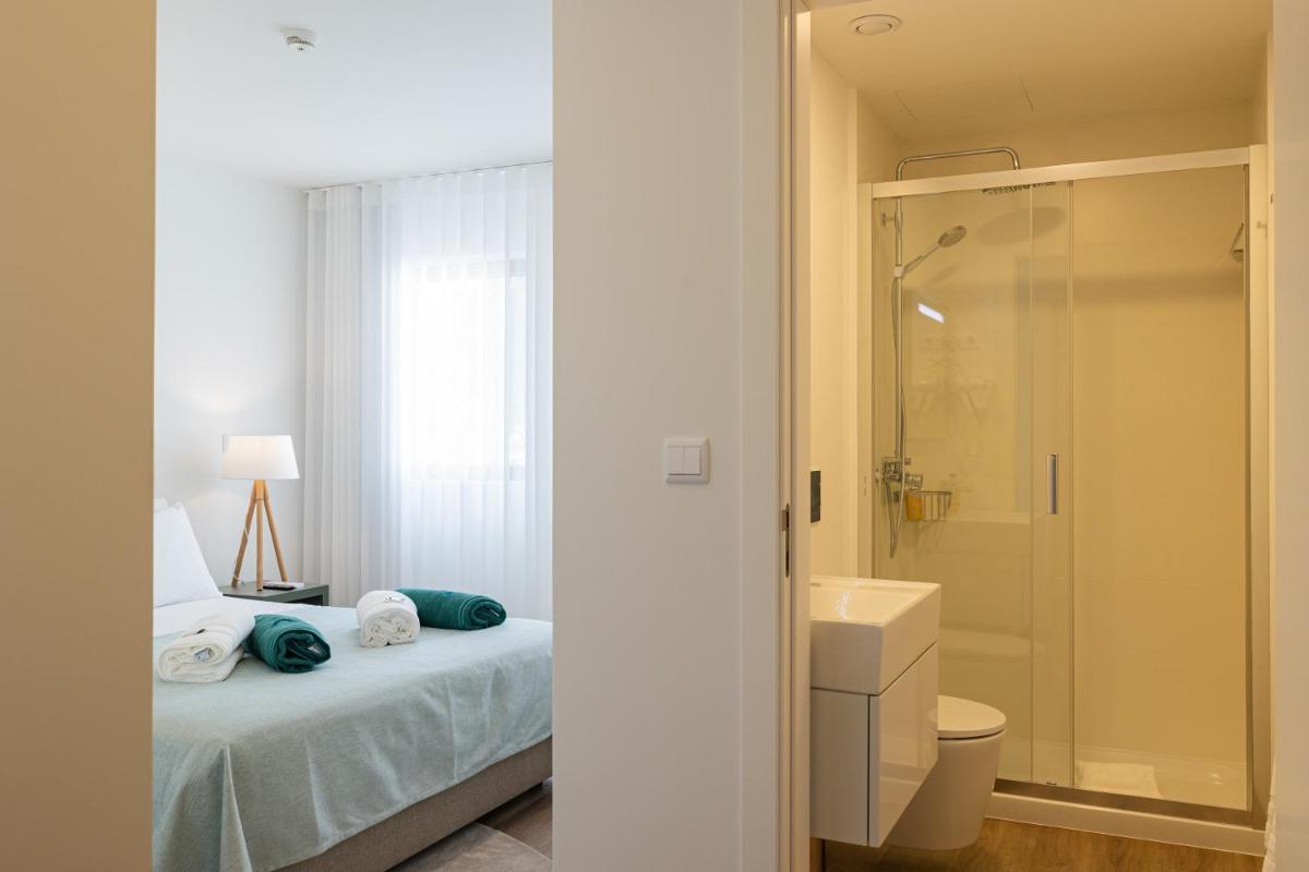 um banheiro com uma cama, um chuveiro e um vaso sanitário em Alto do Forte em Ponta Delgada