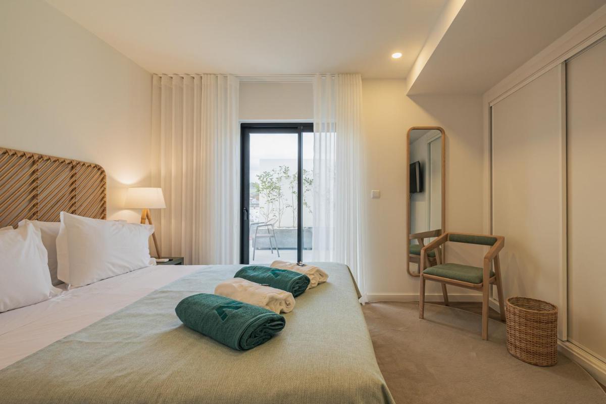 um quarto com uma cama com dois travesseiros em Alto do Forte em Ponta Delgada