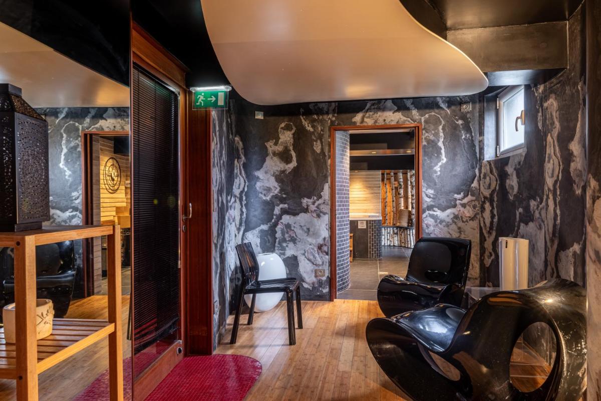 - un salon avec une moto dans une pièce dans l'établissement Le Bailliage Hôtel & Spa, à Salers