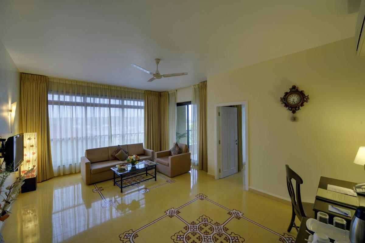 a living room with a couch and a table at The Crown Goa in Panaji