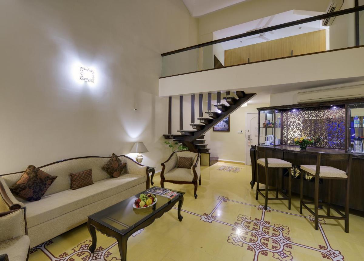 a living room with a couch and a table at The Crown Goa in Panaji