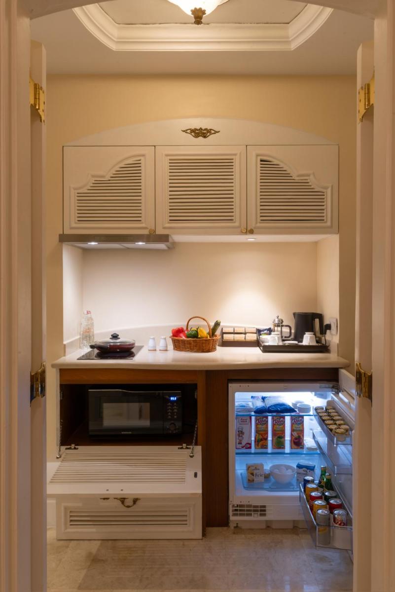 a kitchen with an open refrigerator filled with food at The Leela Palace Bengaluru in Bengaluru a kitchen with an open refrigerator filled with food at The Leela Palace Bengaluru in Bengaluru