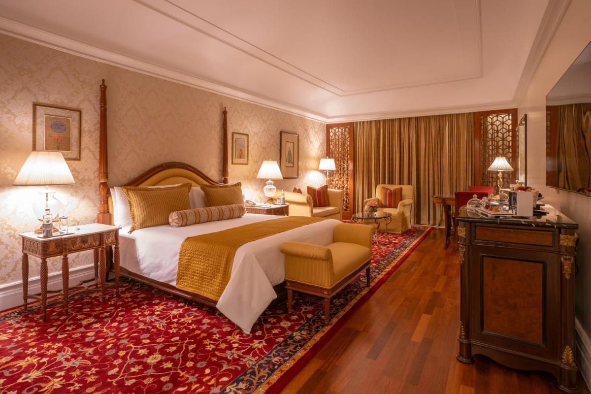 a hotel room with a bed and a living room at The Leela Palace Bengaluru in Bengaluru a hotel room with a bed and a living room at The Leela Palace Bengaluru in Bengaluru