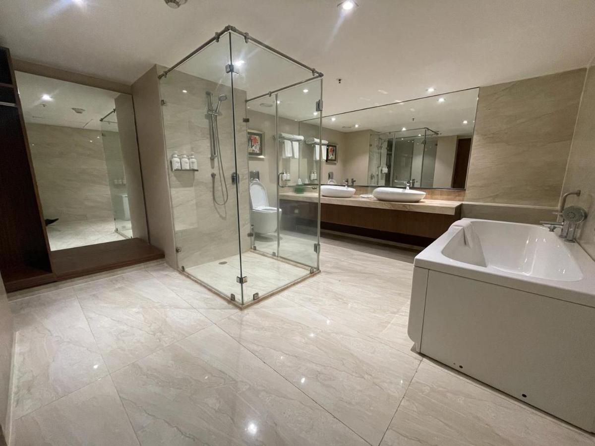 a bathroom with a shower and a sink and a tub at Holiday Inn Kolkata Airport by IHG in Kolkata +76 photos