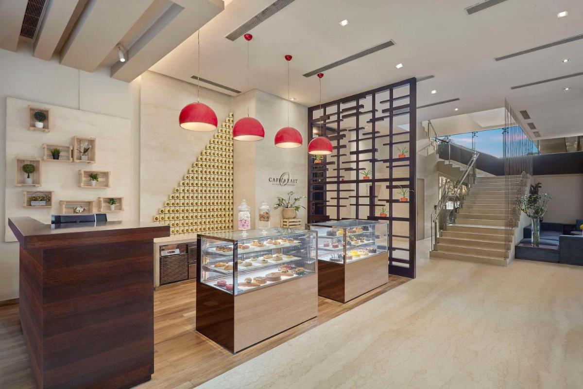 a store with a counter and a staircase at DoubleTree by Hilton Gurugram Baani Square in Gurgaon