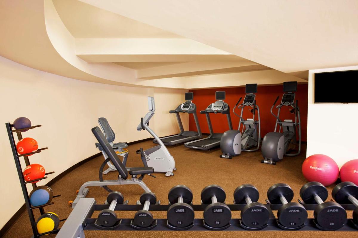 a gym with several exercise equipment in a room at Hilton Garden Inn, Trivandrum in Trivandrum