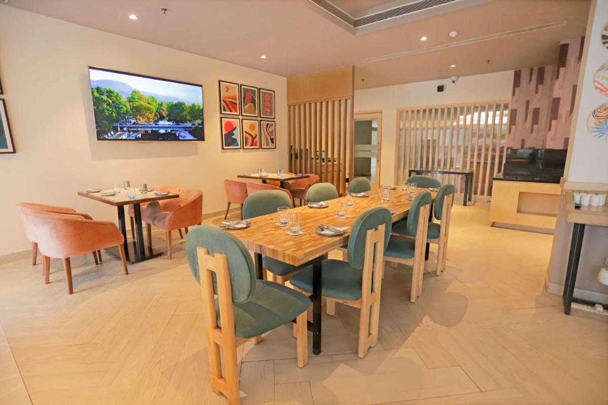 a dining room with a long table and chairs at Park Inn by Radisson,South Delhi in New Delhi a dining room with a long table and chairs at Park Inn by Radisson,South Delhi in New Delhi