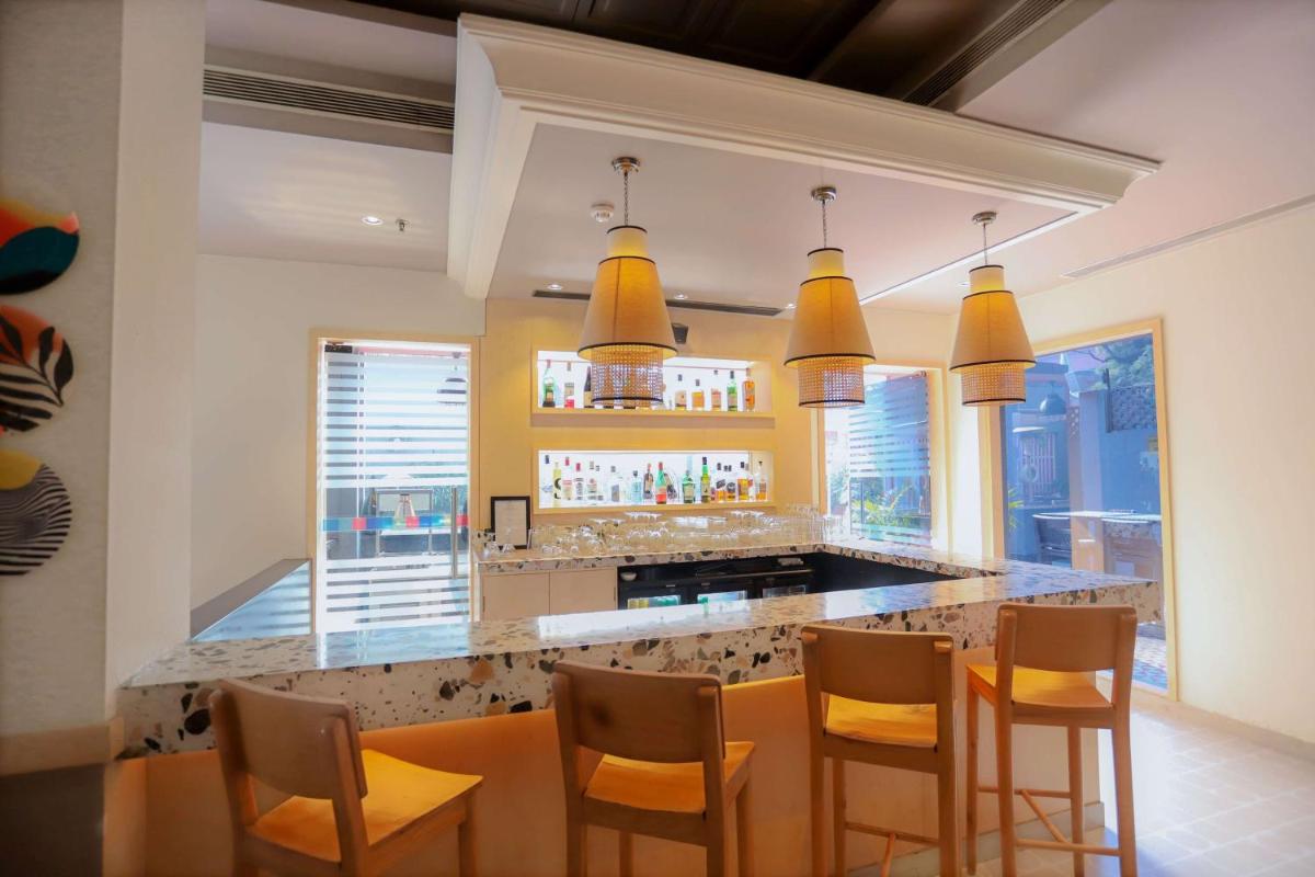 a kitchen with a bar with a table and chairs at Park Inn by Radisson,South Delhi in New Delhi a kitchen with a bar with a table and chairs at Park Inn by Radisson,South Delhi in New Delhi
