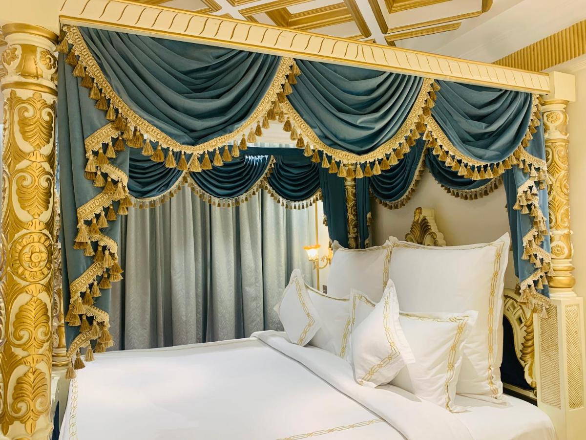 a bedroom with a gold canopy bed with white pillows at The Accord Metropolitan in Chennai