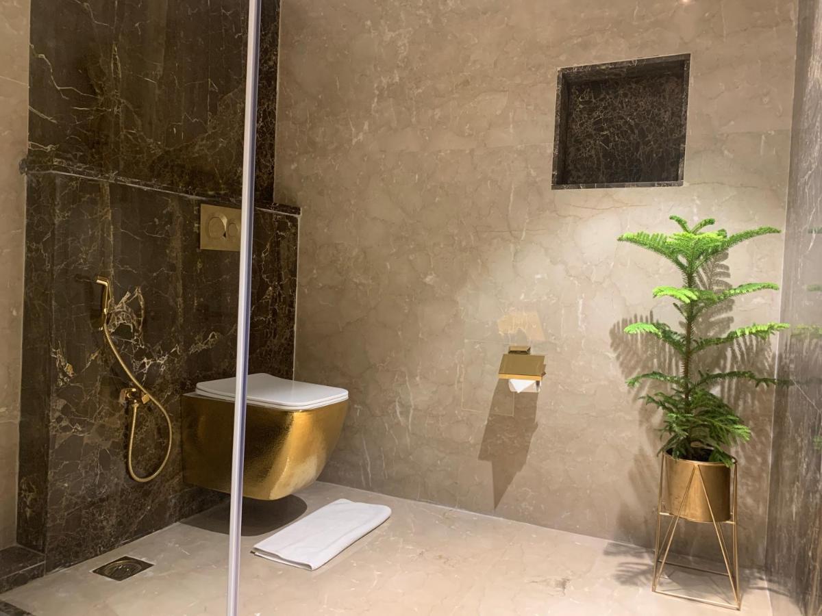 a bathroom with a shower and a toilet and a plant at The Accord Metropolitan in Chennai