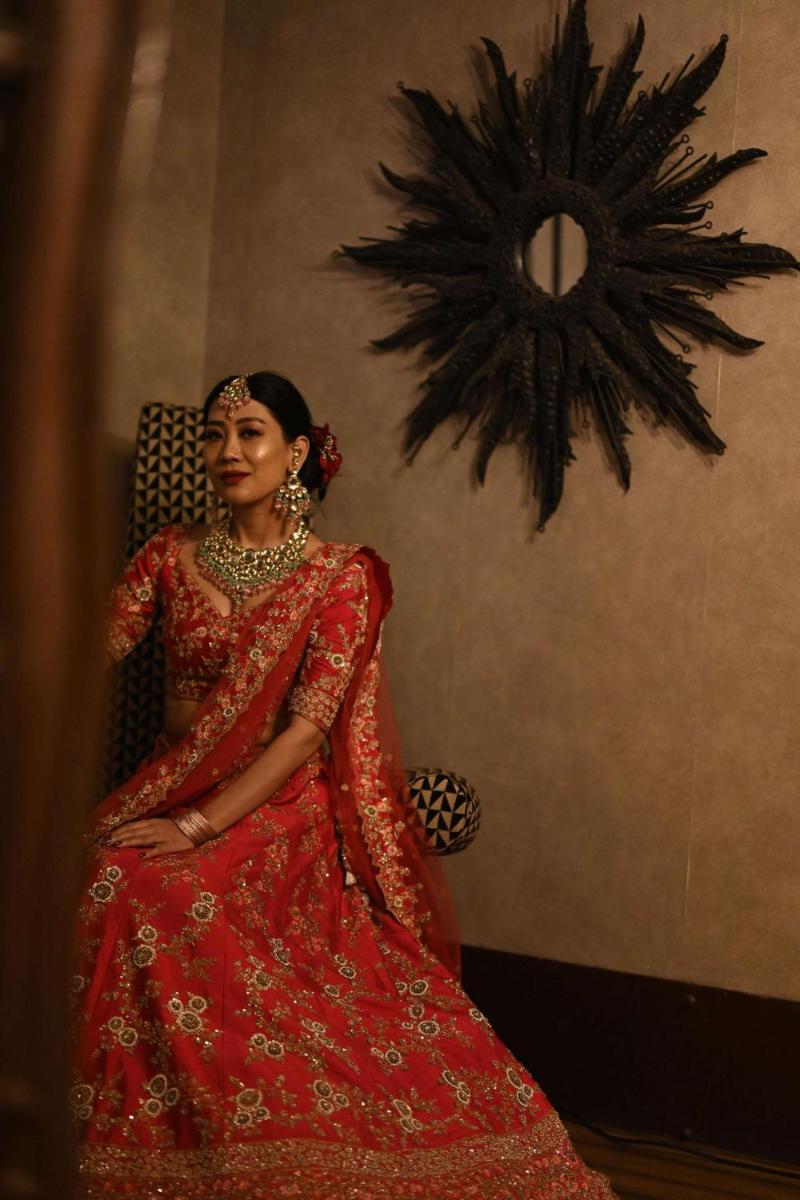 a woman in a red dress sitting on a chair at Radisson Blu Hotel Pune Kharadi in Pune