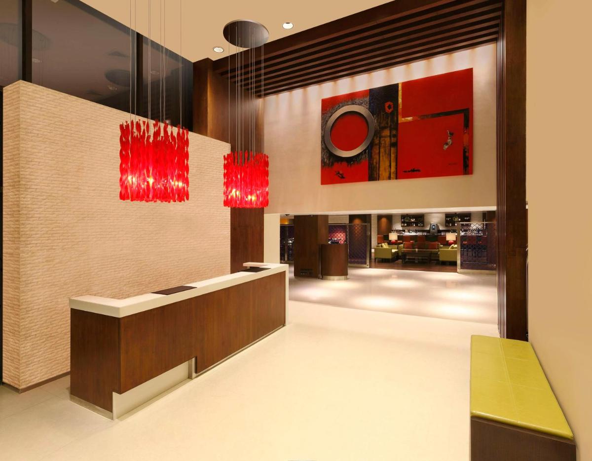 a lobby with red chandeliers and a reception desk at Hilton Garden Inn, Trivandrum in Trivandrum