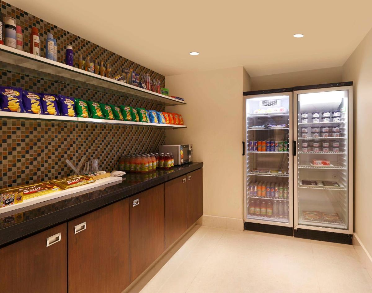 a kitchen with a refrigerator with food in it at Hilton Garden Inn, Trivandrum in Trivandrum