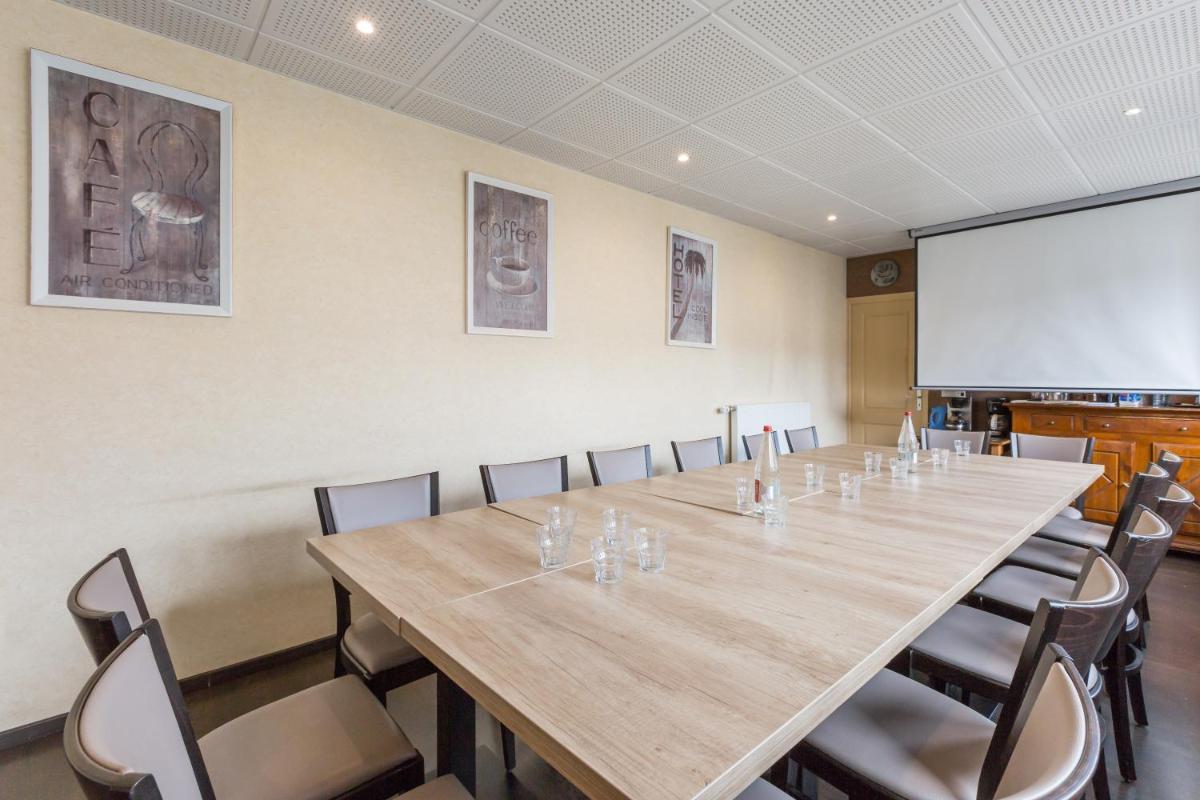 une salle de conférence avec une longue table et des chaises dans l'établissement Logis SPA Hotel Restaurant De La Poste, à Tence 74 autres photos