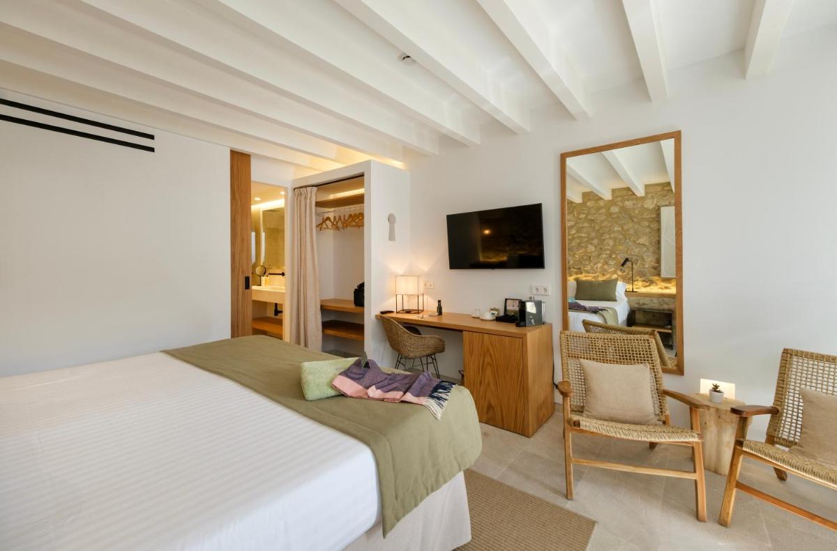 Un dormitorio con una cama y un escritorio con espejo. en Fincahotel Treurer - Olive Grove & Grand House - Adults Only, en Algaida