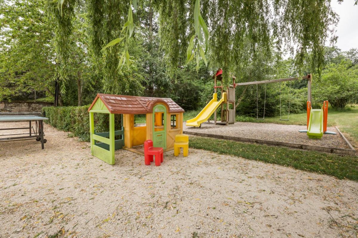 une petite aire de jeux avec toboggan et structure de jeu dans l'établissement Logis SPA Hotel Restaurant De La Poste, à Tence