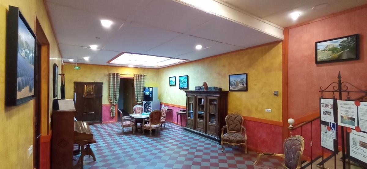 Cette chambre aux murs colorés dispose d'une table et de chaises. dans l'établissement Les Arcades Le Lion D'or, à Buis-les-Baronnies