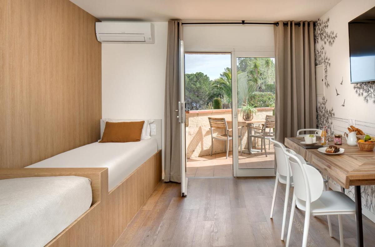 une chambre d'hôtel avec un lit et une table à manger dans l'établissement Hôtel & Spa Les Mouettes, à Argelès-sur-Mer
