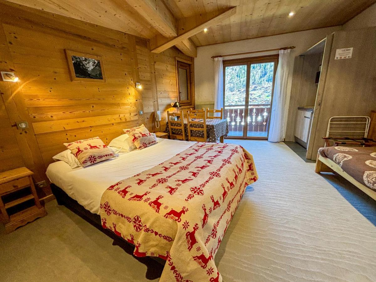 - une chambre avec un grand lit dans une cabane en rondins dans l'établissement Hôtel Igloo, à Morzine