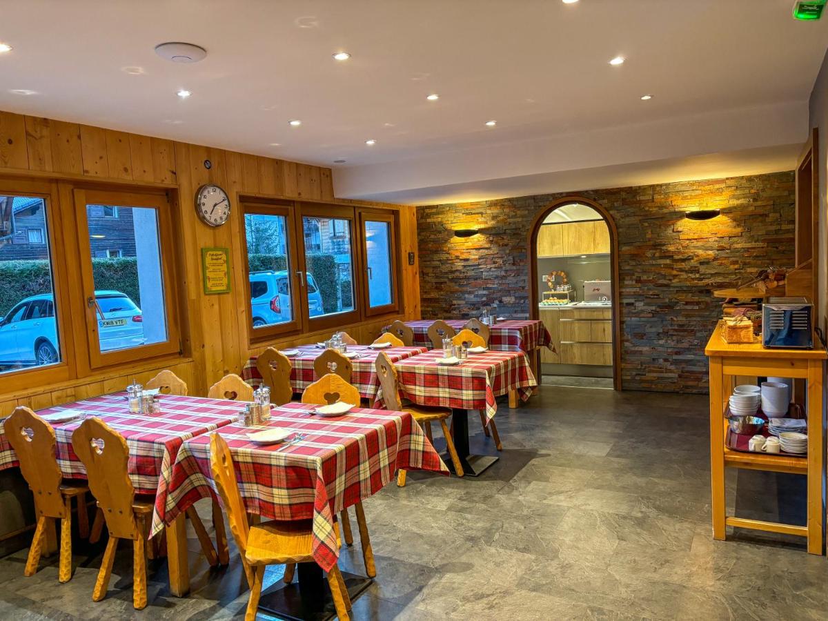un restaurant avec des tables recouvertes de nappes rouges et blanches dans l'établissement Hôtel Igloo, à Morzine