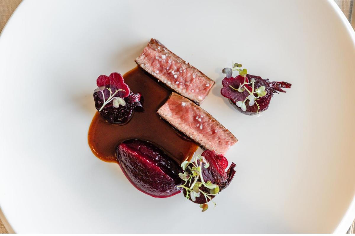 une assiette blanche avec dessert à base de viande et de fraises dans l'établissement Hôtel Alpina & SPA - Restaurant Oxalis, aux Gets