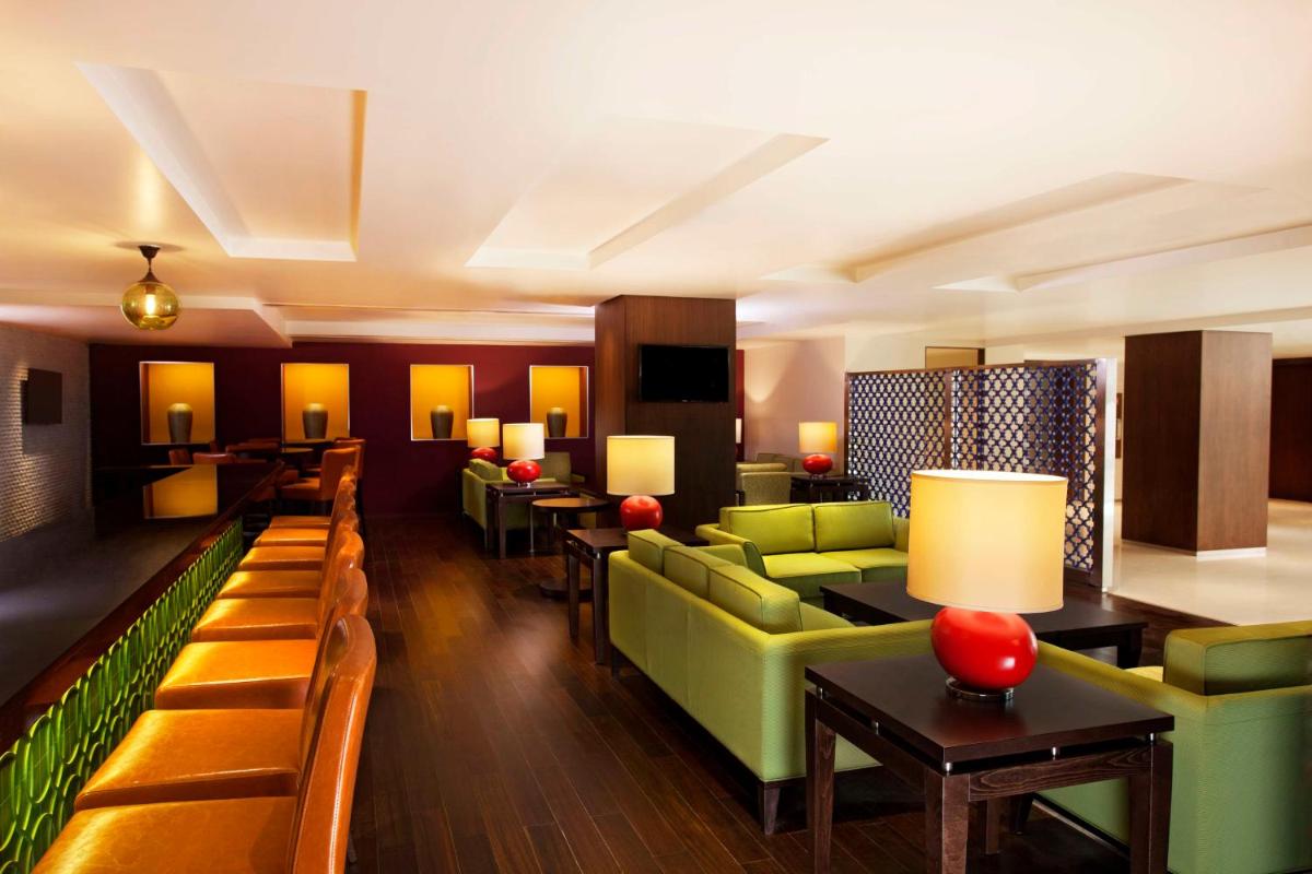 a hotel lobby with green couches and tables at Hilton Garden Inn, Trivandrum in Trivandrum