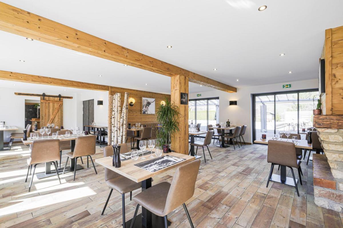 une salle à manger avec tables et chaises et une cheminée dans l'établissement Hôtel et Spa les Clarines, à Corrençon-en-Vercors