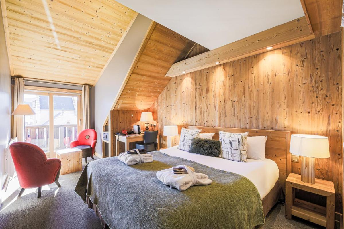 une chambre d'hôtel avec un lit avec des serviettes dessus dans l'établissement Hôtel et Spa les Clarines, à Corrençon-en-Vercors