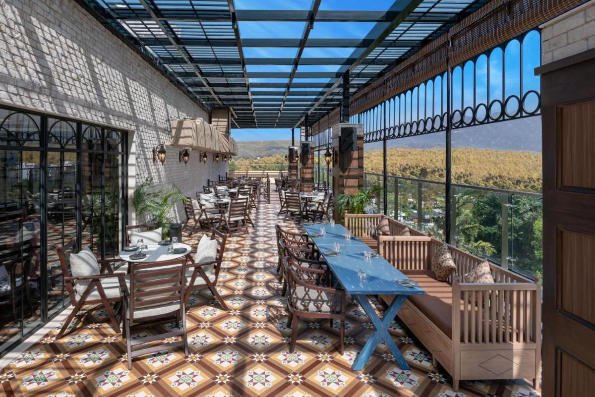 a restaurant with tables and chairs on a patio at Hyatt Centric Rajpur Road Dehradun in Dehradun