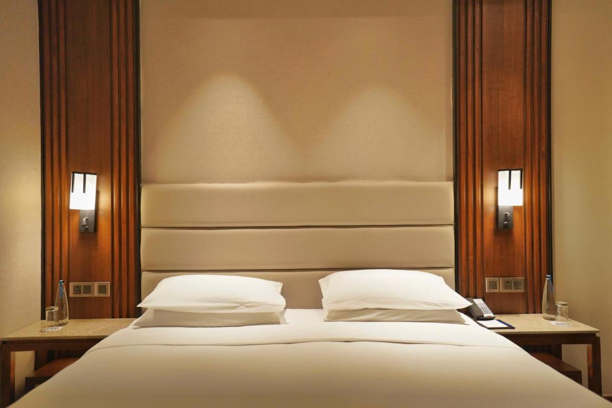 a bedroom with a large bed with two pillows at Hyatt Centric Rajpur Road Dehradun in Dehradun