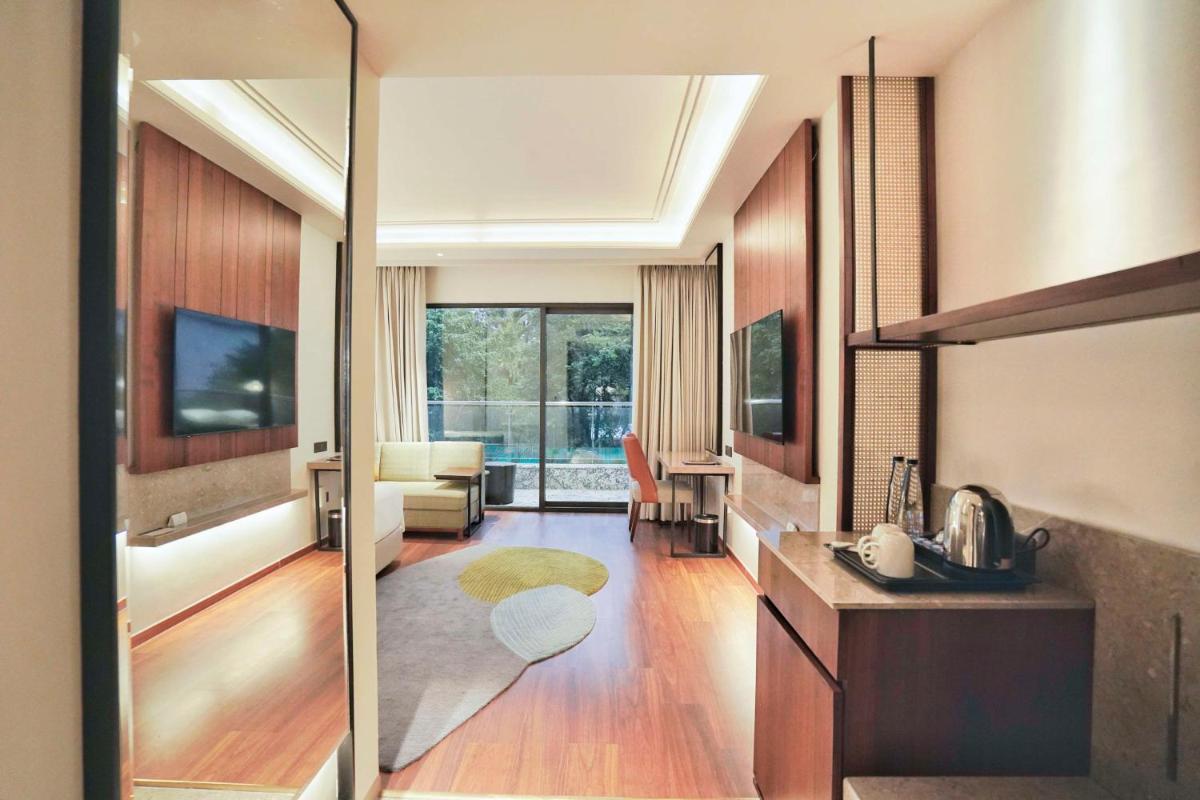 a living room with a kitchen and a living room with a television at Hyatt Centric Rajpur Road Dehradun in Dehradun