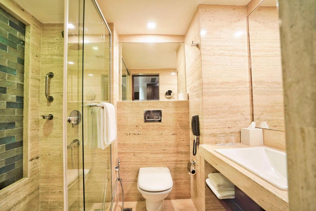 a bathroom with a toilet and a sink and a shower at Hyatt Centric Rajpur Road Dehradun in Dehradun