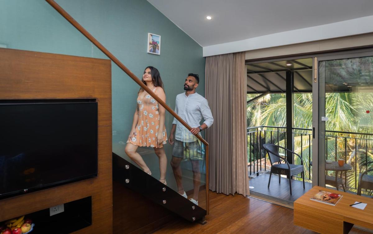 a man and a woman standing on a staircase in a house at Novotel Goa Candolim in Candolim a man and a woman standing on a staircase in a house at Novotel Goa Candolim in Candolim