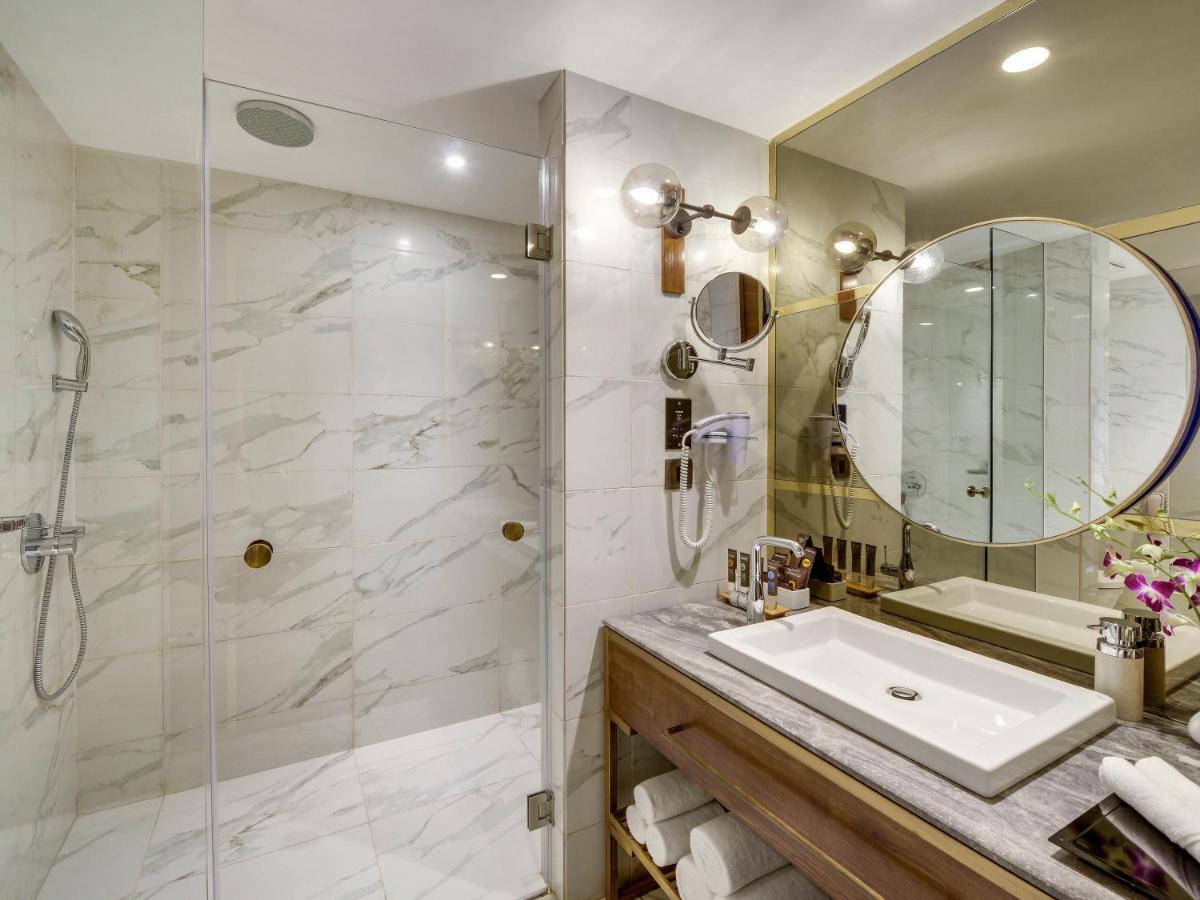 a bathroom with a sink and a shower at Novotel Goa Candolim in Candolim a bathroom with a sink and a shower at Novotel Goa Candolim in Candolim