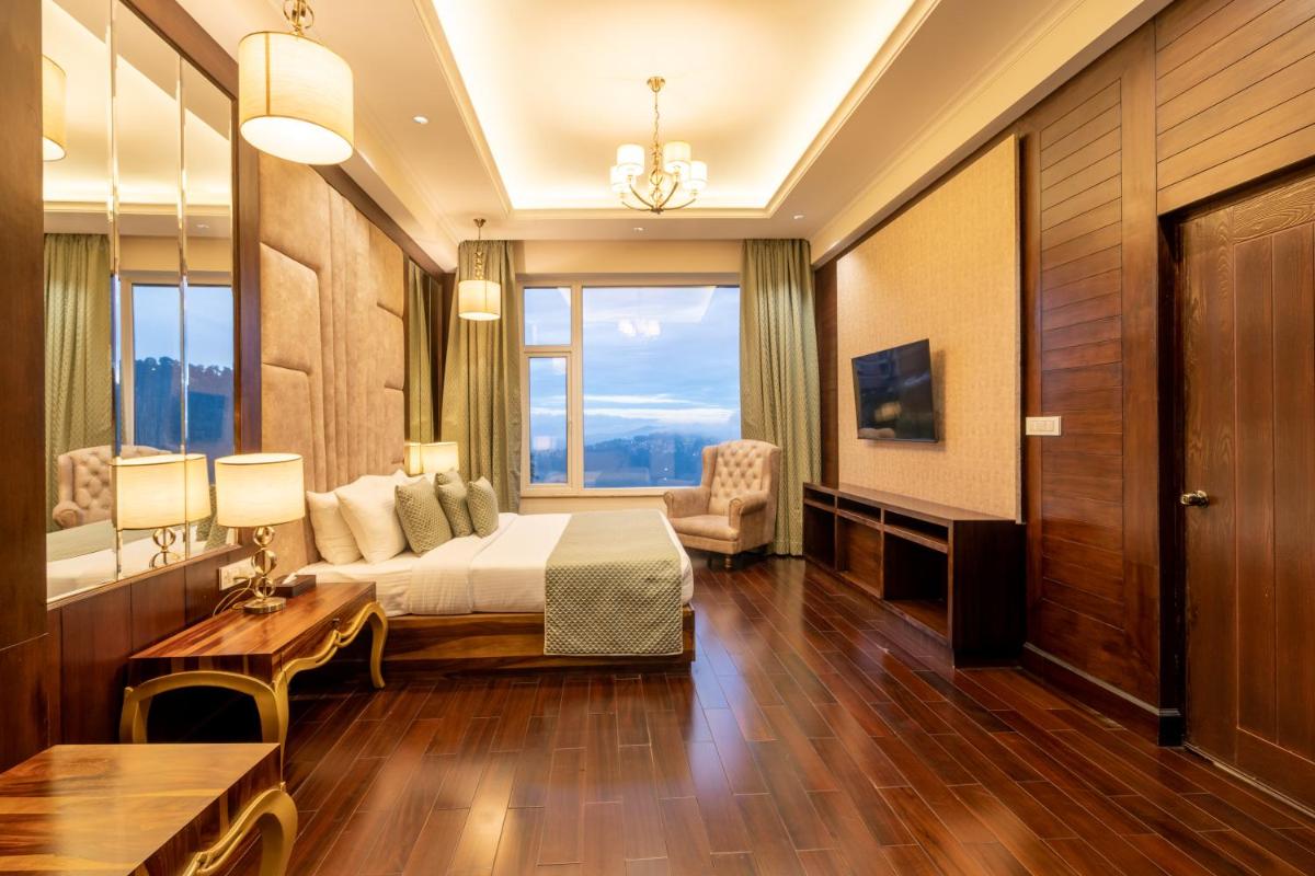 a hotel room with a bed and a large window at The Orchid Shimla in Shimla