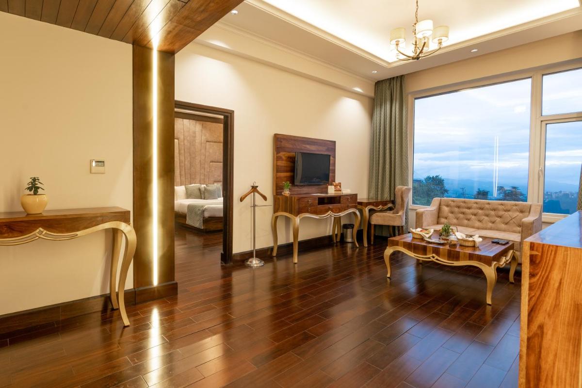 a living room with a couch and a table at The Orchid Shimla in Shimla