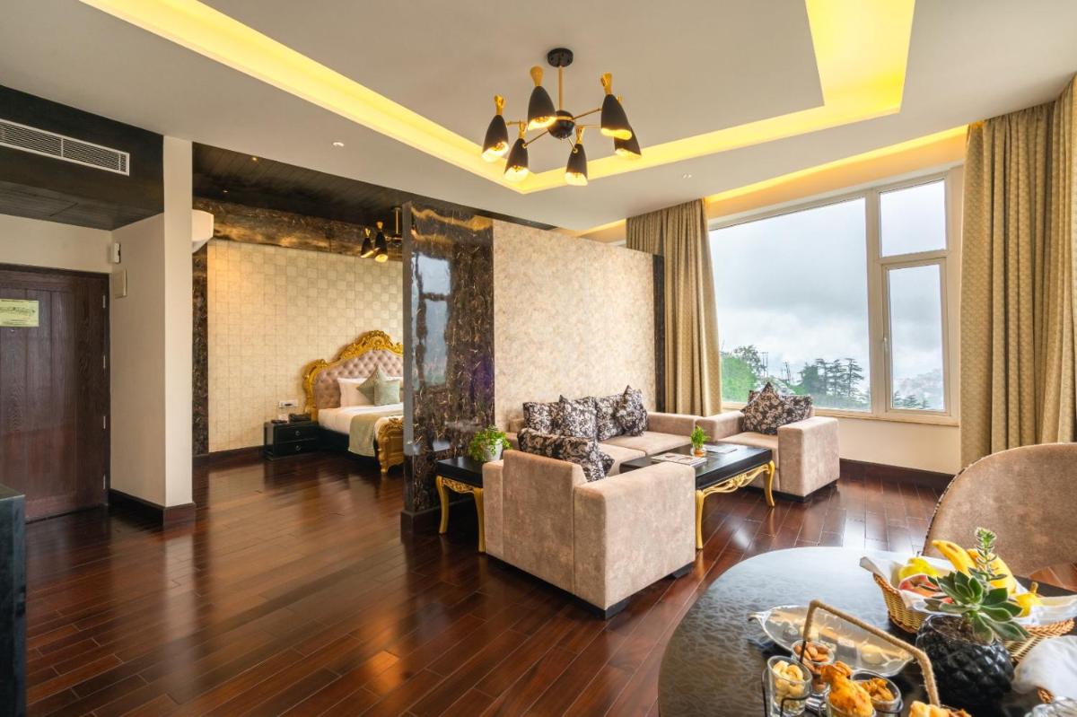 a hotel room with a bed and a living room at The Orchid Shimla in Shimla
