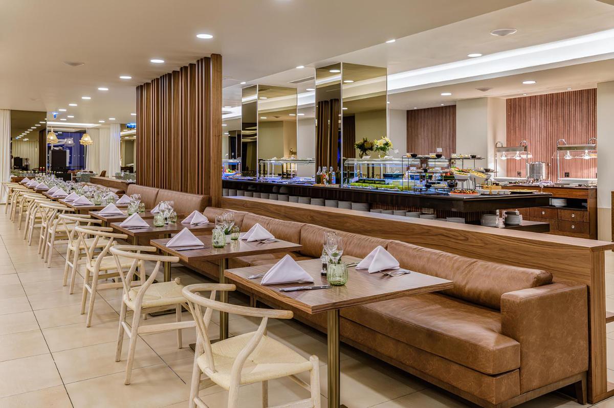 uma fileira de mesas e cadeiras em um restaurante em NAU Sao Rafael Suites - All Inclusive em Albufeira mais 31 fotografias