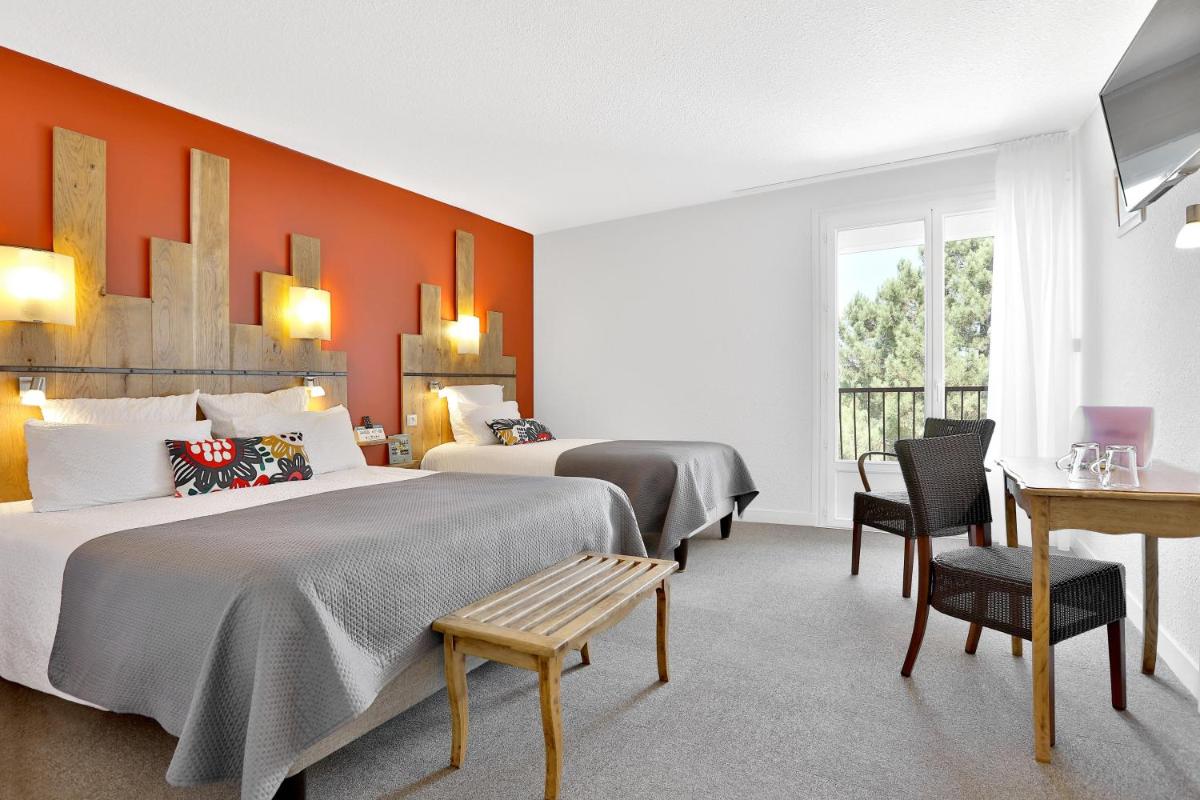Un ou plusieurs lits dans un hébergement de l'établissement Logis Hotel Le Tropicana