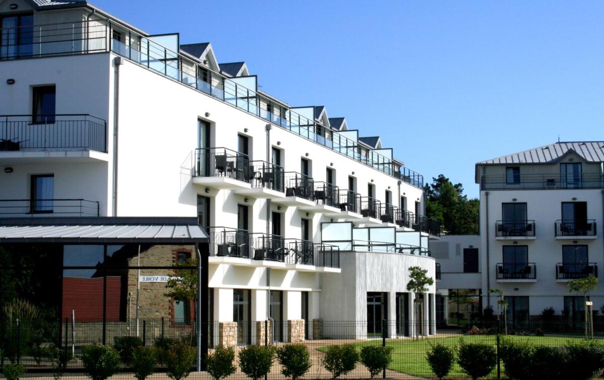 un bâtiment blanc avec des balcons sur le côté dans l'établissement Thalasso Concarneau Spa Marin Resort, à Concarneau