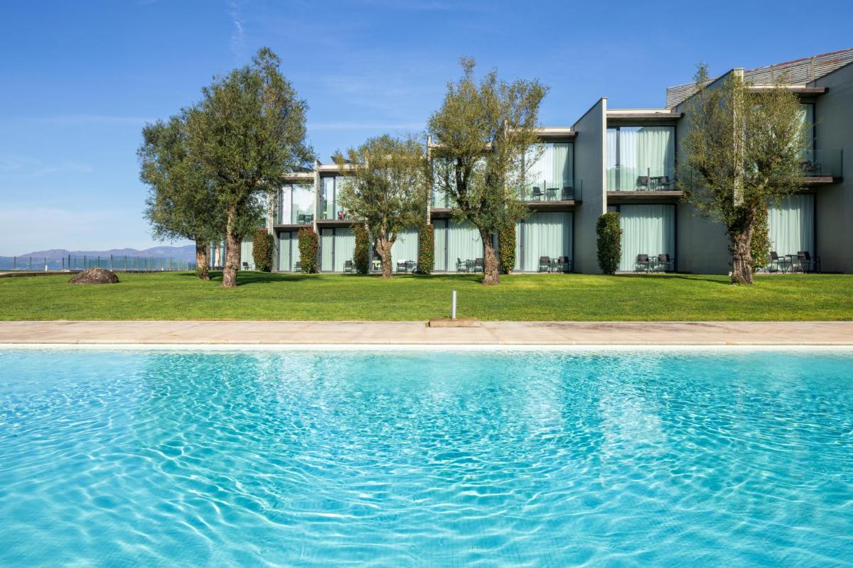 uma casa com piscina em frente a um prédio em Tempus Hotel & Spa em Ponte da Barca uma casa com piscina em frente a um prédio em Tempus Hotel & Spa em Ponte da Barca