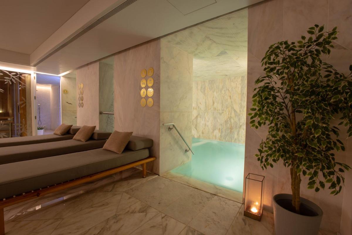 um banheiro com sofá e banheira com planta em Lisboa Pessoa Hotel em Lisboa