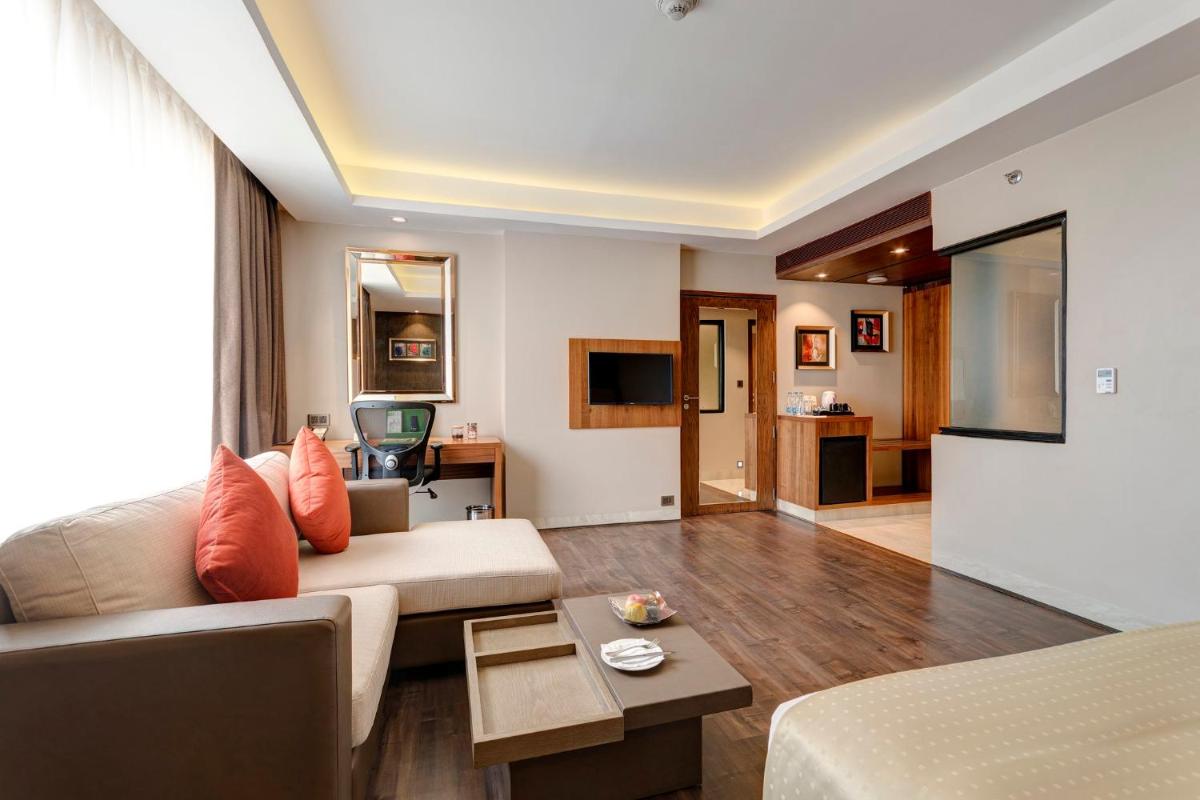 a living room with a couch and a table at Holiday Inn Kolkata Airport by IHG in Kolkata