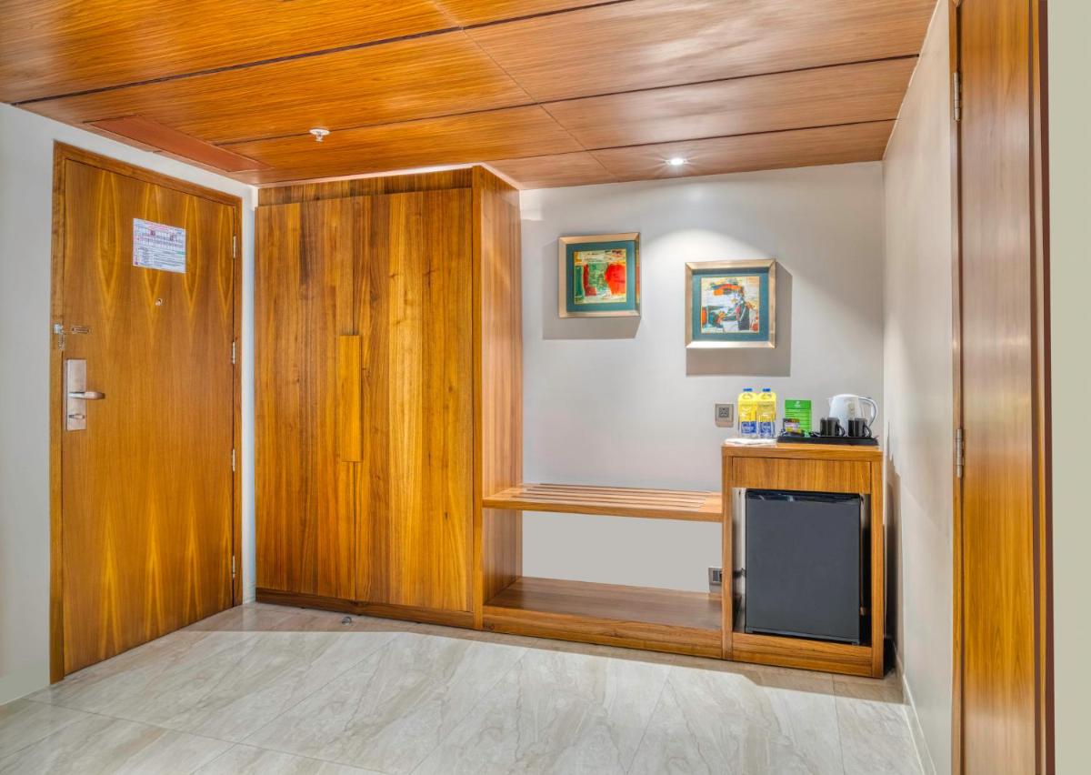 a room with wooden walls and a kitchen with a counter at Holiday Inn Kolkata Airport by IHG in Kolkata