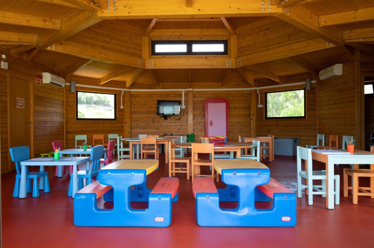 uma sala de aula com mesas e cadeiras num edifício de madeira em Vila Gale Nautico em Armação de Pêra mais 92 fotografias