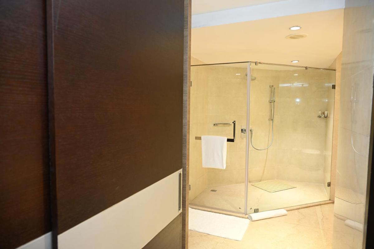 a shower with a glass door in a bathroom at The LaLiT New Delhi in New Delhi