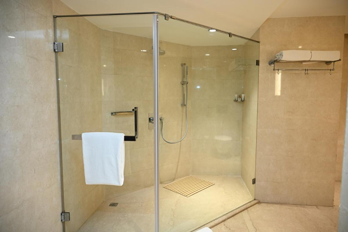 a shower stall with a glass door in a bathroom at The LaLiT New Delhi in New Delhi