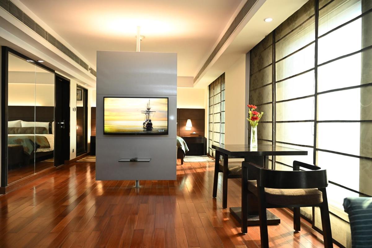 a living room with a television and a table at The LaLiT New Delhi in New Delhi