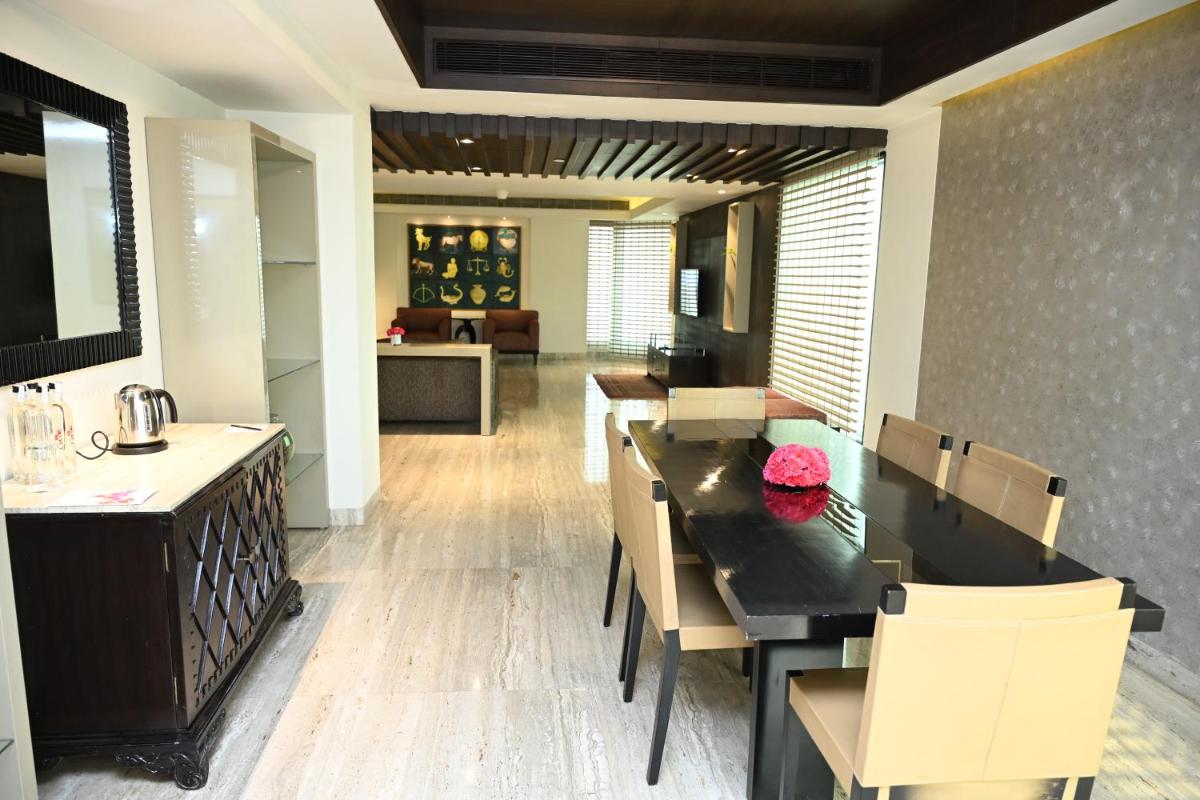 a dining room with a table and chairs at The LaLiT New Delhi in New Delhi