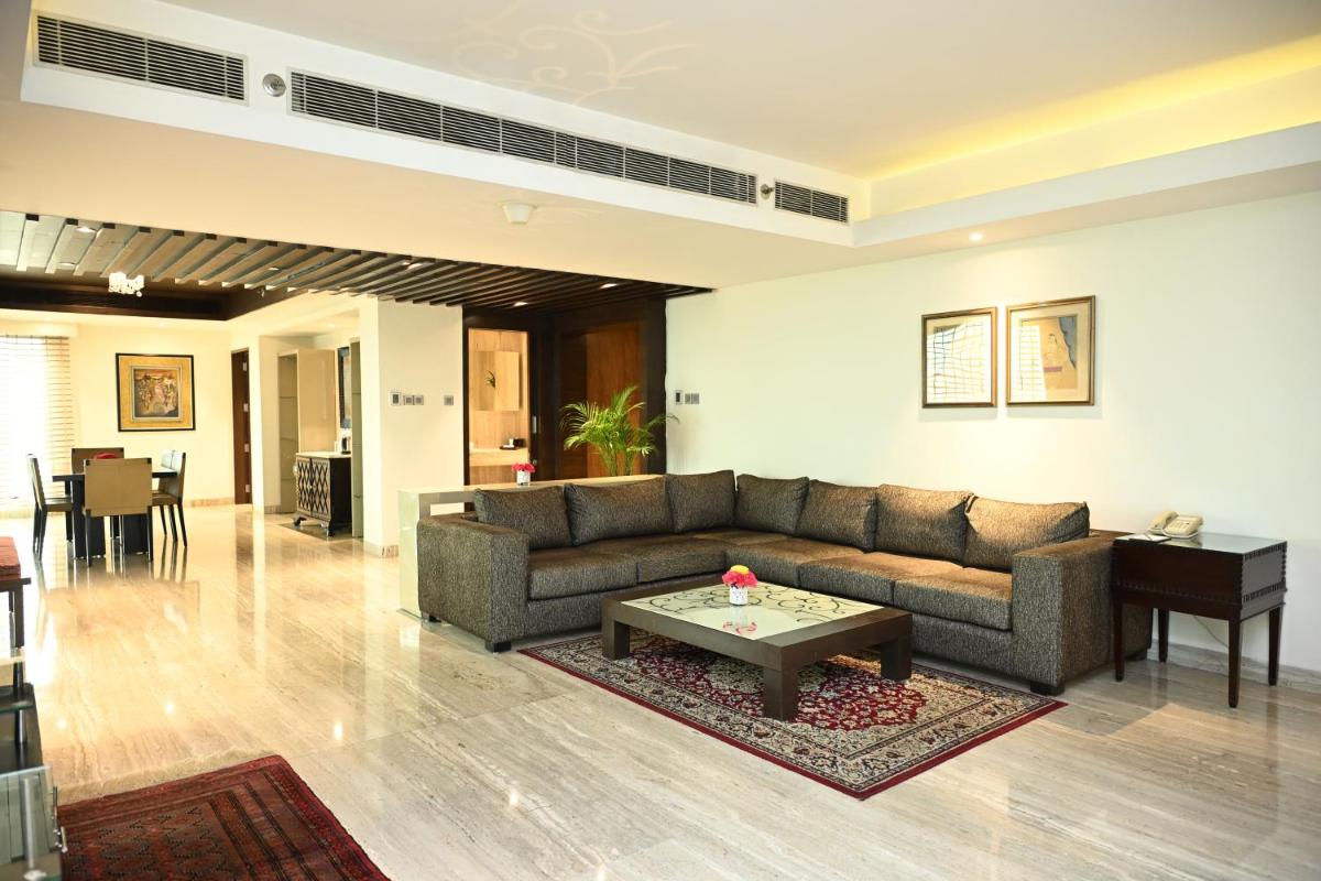 a living room with a couch and a table at The LaLiT New Delhi in New Delhi